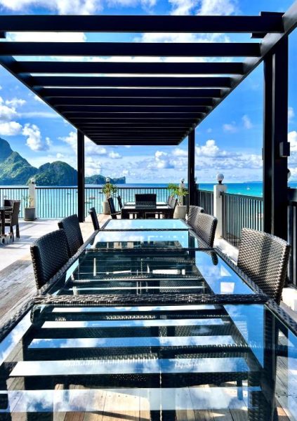 Terraza con mesas de cristal y vistas al mar turquesa en S Resort El Nido, Filipinas