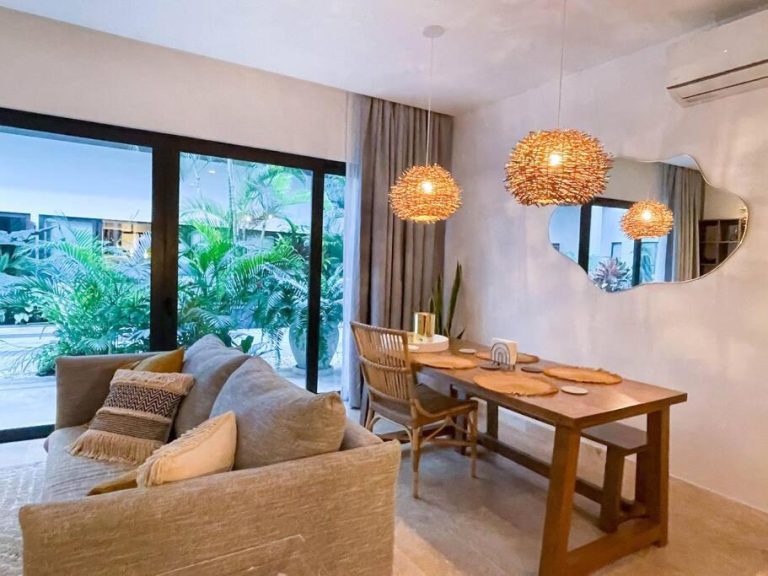 Sala comedor con lámparas de mimbre y vista a jardín tropical en Ipana by Andiani Travel