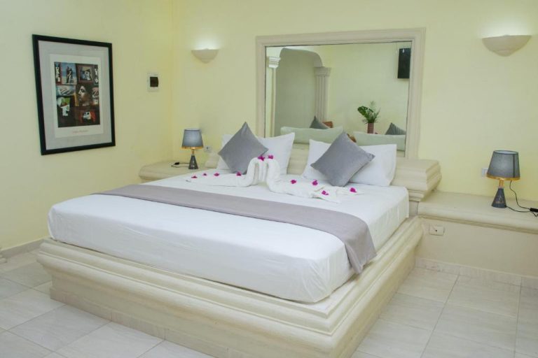 Habitación de lujo con cama doble en plataforma elevada y espejo en Aparthotel Castillo Real
