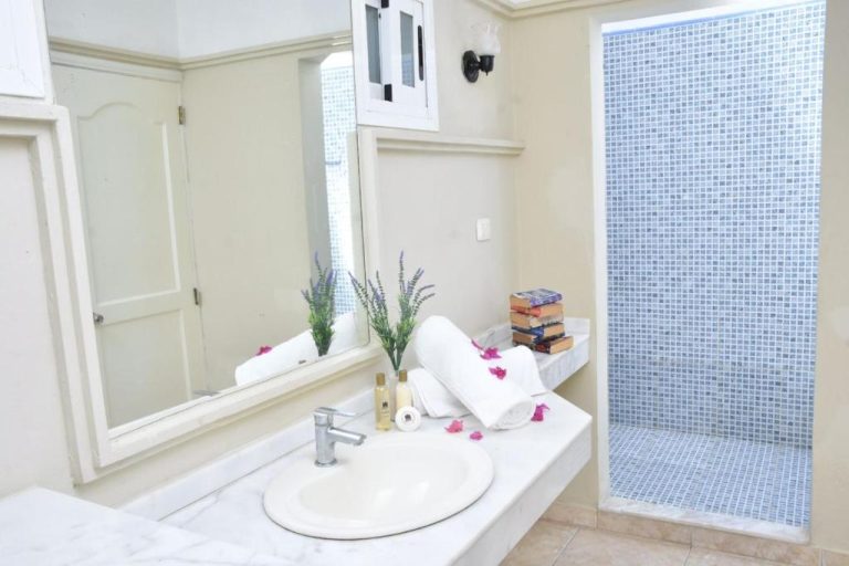 Baño elegante con ducha de mosaico azul y lavabo de mármol en Aparthotel Castillo Real