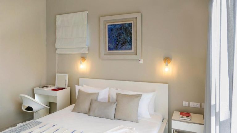 Habitación doble elegante con cama blanca y decoración minimalista en Royal Green Wellness Resort