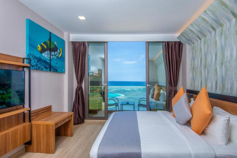 Habitación con cama doble y balcón con vistas al mar turquesa en Triton Prestige Seaview and Spa