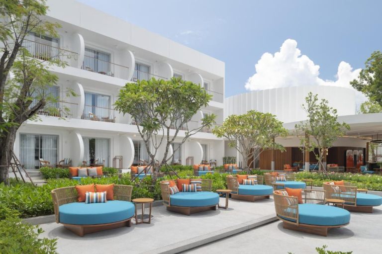 Terraza exterior con tumbonas redondas azules y jardines del Avani Chaweng Samui Hotel & Beach Club