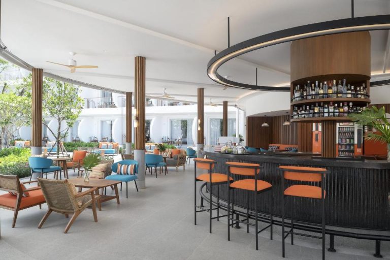 Bar con taburetes naranjas y zona de terraza tropical en Avani Chaweng Samui Hotel & Beach Club Adults Only