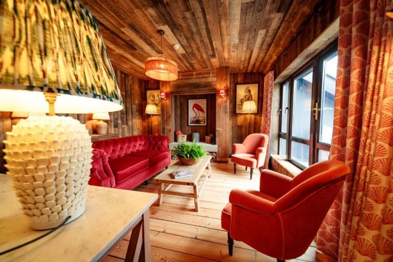 Salón rústico con sofás rojos y paredes de madera del Glasson Lakehouse Hotel