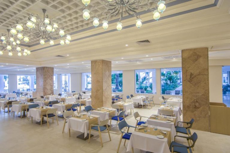 Elegante restaurante principal del Royal Azur Thalassa con mesas vestidas y lámparas de araña