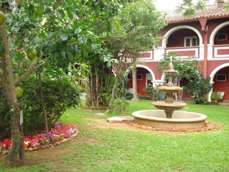 Jardín colonial con fuente ornamental y vegetación tropical del Gran Hotel del Paraguay en Asunción
