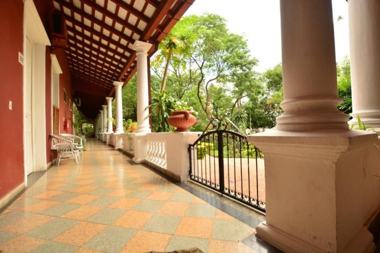 Corredor colonial con columnas blancas y jardín tropical del Gran Hotel del Paraguay en Asunción