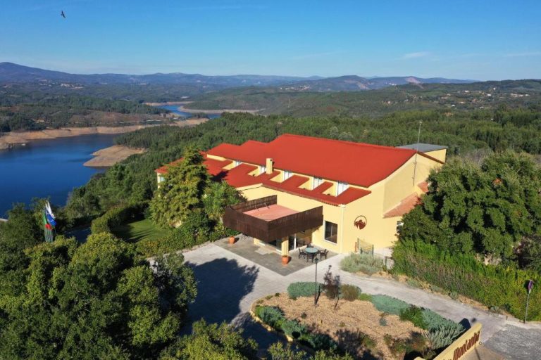 Vista aérea del Hotel Da Montanha con tejado rojo rodeado de naturaleza y lago en Portugal