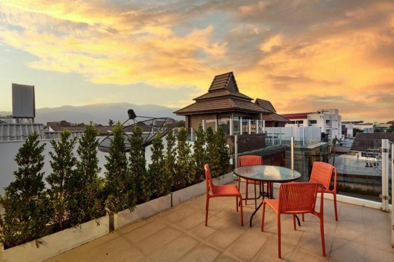 Terraza exterior con vistas al atardecer y gazebo del Be Phrasingh Hotel en Chiang Mai