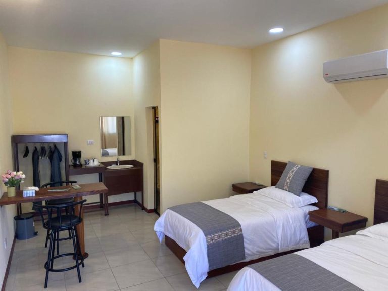 Habitación doble twin con dos camas, escritorio y aire acondicionado en Villa Garita Inn