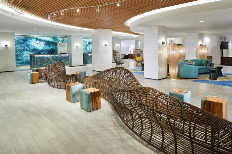 Lobby moderno con escultura de mimbre y decoración tropical del OUTRIGGER Waikiki Beachcomber Hotel en Hawái