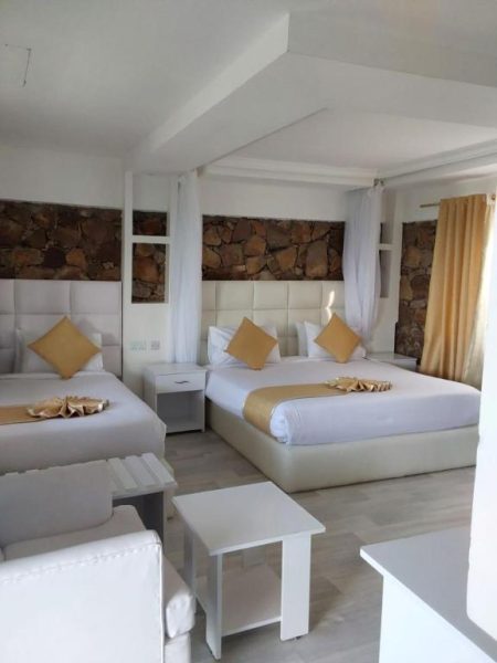 Habitación doble de lujo con dos camas y pared de piedra natural en Takawiri Victoria Sands