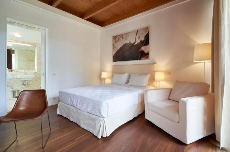 Habitación doble con techo de madera y baño en suite del Hotel Porto Santo & Spa