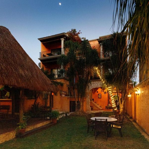 Jardín y terraza exterior iluminada del Hotel Lunata 5th Avenue en Playa del Carmen al atardecer