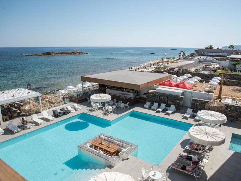 Piscina exterior con tumbonas y bar junto al mar en el hotel Enorme Ammos Beach Adults Only