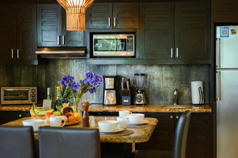 Cocina totalmente equipada con electrodomésticos modernos y mesa de comedor en El Taj Oceanfront Condo Hotel