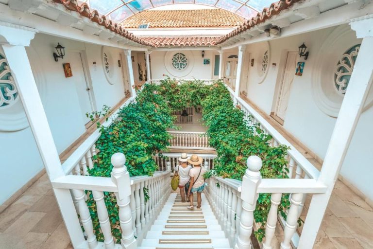 Patio interior con escaleras blancas y vegetación tropical del Hotel Kartaxa en Cartagena