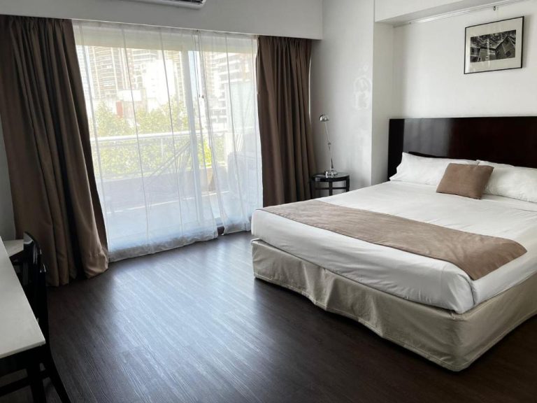 Habitación doble con cama king size y balcón con vistas a la ciudad en Awwa Suites & Spa