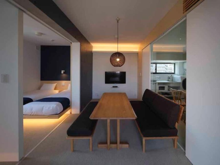 Suite del East Square Tokyo con comedor de madera, dormitorio doble y cocina equipada con diseño minimalista japonés