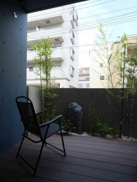 Terraza exterior con jardín de bambú y piedra decorativa del East Square Tokyo
