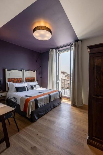 Habitación doble con balcón y vistas al exterior en Hotel Priori Secret Garden con decoración en tonos morados