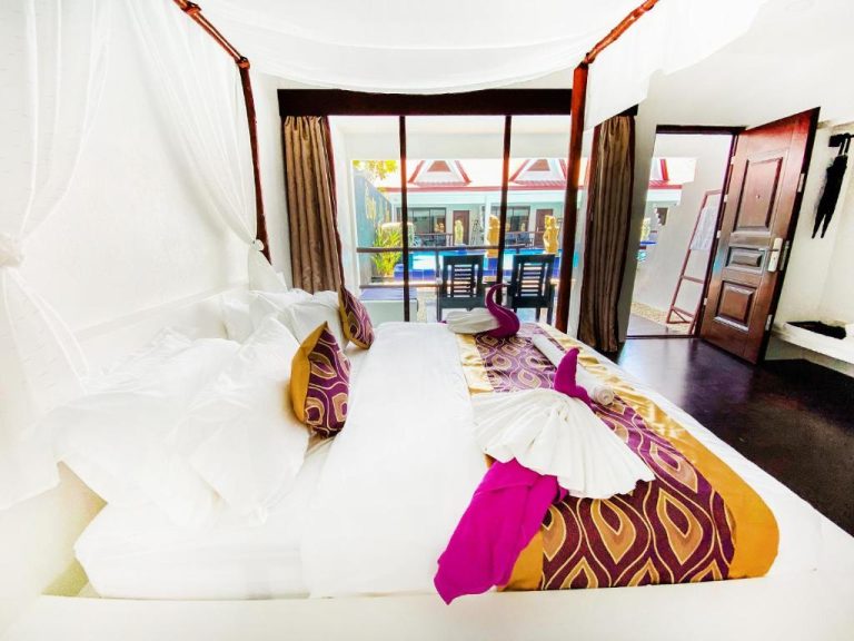 Habitación con cama de dosel y vistas a la piscina en Carpe Diem Villas & Resort