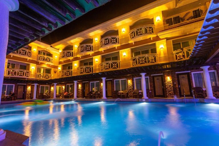 Piscina interior iluminada de noche en el Boracay Mandarin Island Hotel con vistas a los balcones