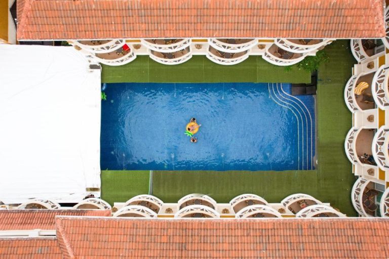 Vista aérea de la piscina exterior del Boracay Mandarin Island Hotel con tumbonas y jardín