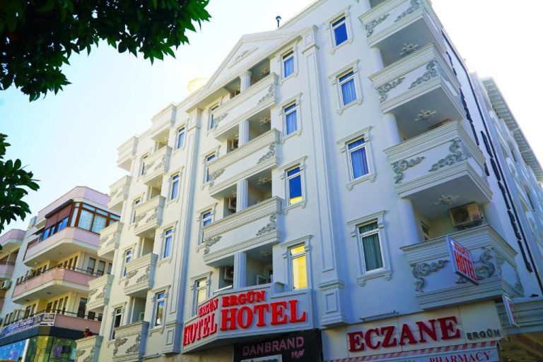 Fachada exterior blanca del Ergün Hotel con decoración ornamental y señalización en primer plano