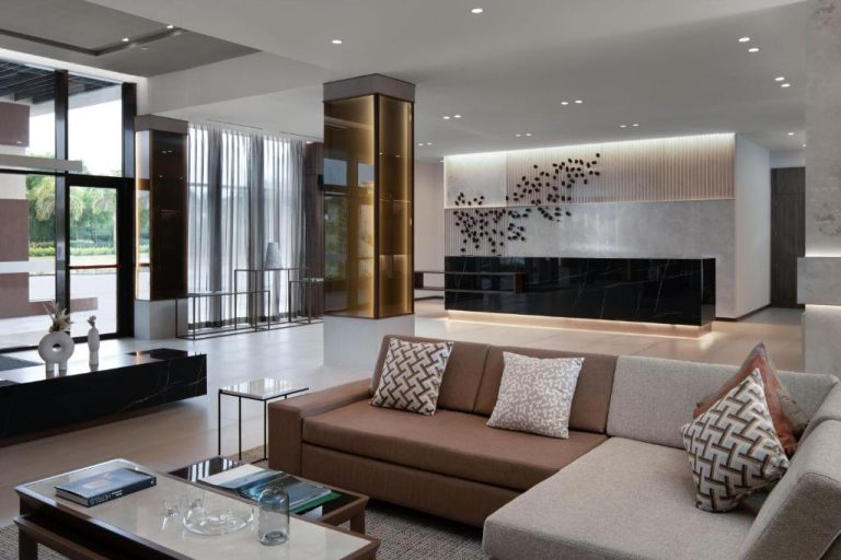 Elegante lobby y recepción del AC Hotel by Marriott Punta Cana con sofás modernos y decoración de lujo