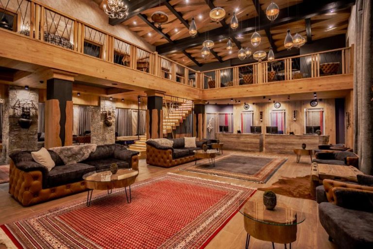 Lujoso lobby con sofás de cuero y decoración en madera del Kashmir Wellness & SPA Hotel Adults Only