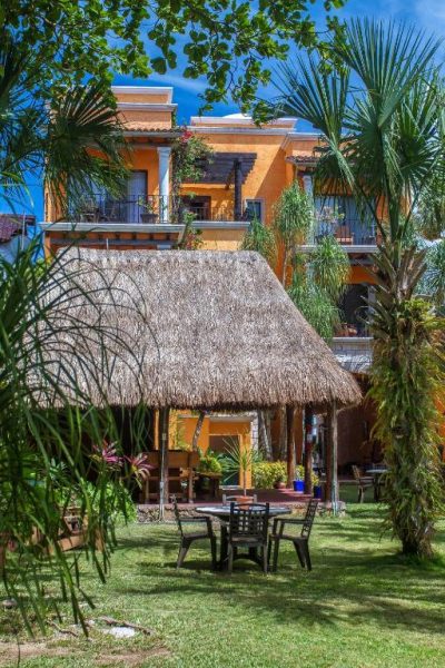 Jardín tropical con palapa y zona de descanso exterior del Hotel Lunata 5th Avenue en Playa del Carmen