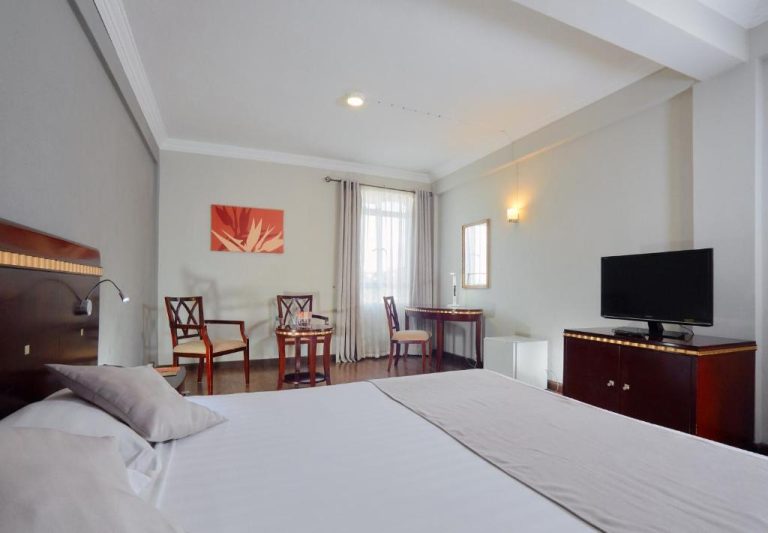 Habitación doble superior con cama king size y zona de escritorio en Gold Crest Hotel