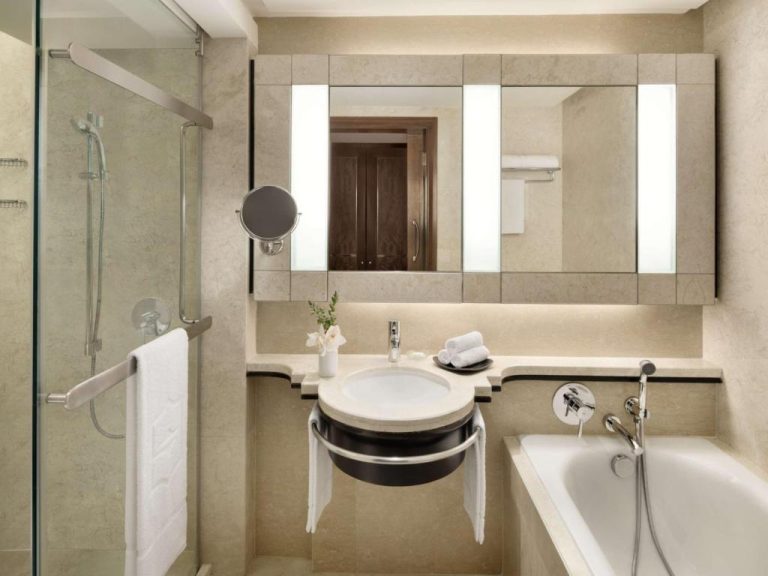 Baño de lujo con mármol, bañera, ducha y lavabo circular del Shangri-La Kuala Lumpur