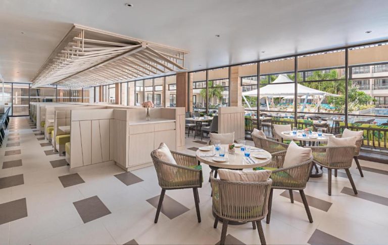 Restaurante interior con vistas a la piscina y jardines del Henann Park Resort en Boracay