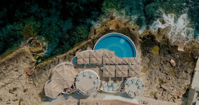 Vista aérea de la piscina circular en el acantilado del 1926 Le Soleil Hotel & Spa junto al mar