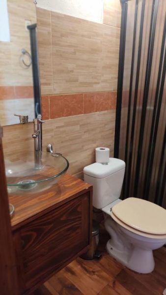 Baño privado con lavabo de cristal y ducha en la Posada Don Manuel