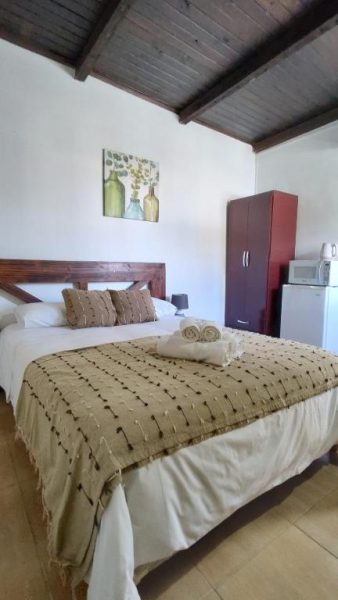 Habitación doble con cama matrimonial y techo de madera en Posada Don Manuel