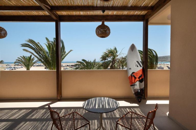 Terraza con tabla de surf y vistas a la playa del Prasonisi Lighthouse Boutique Hotel en Rodas