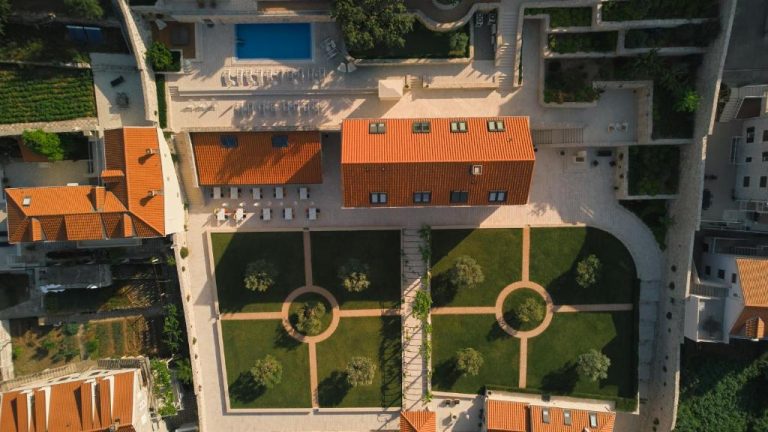 Vista aérea del Palace Natali con jardines geométricos, piscina exterior y tejados naranjas tradicionales
