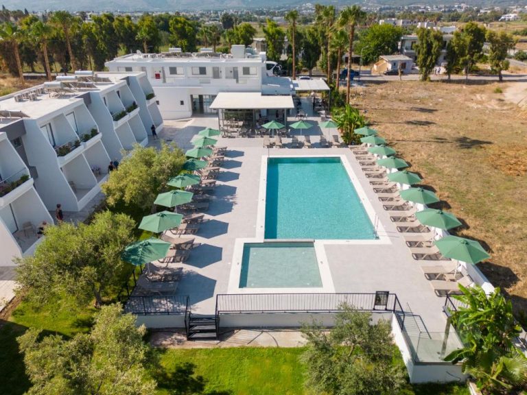 Vista aérea de la piscina exterior con tumbonas y sombrillas verdes del Smaragdi Kos Hotel