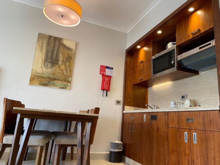 Cocina y comedor equipados con microondas y mesa de madera en Hotel Studio