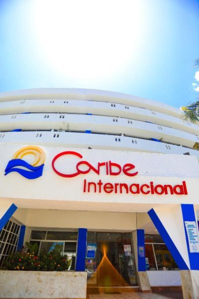 Fachada principal y entrada del Hotel Caribe Internacional Cancún con arquitectura blanca y logo