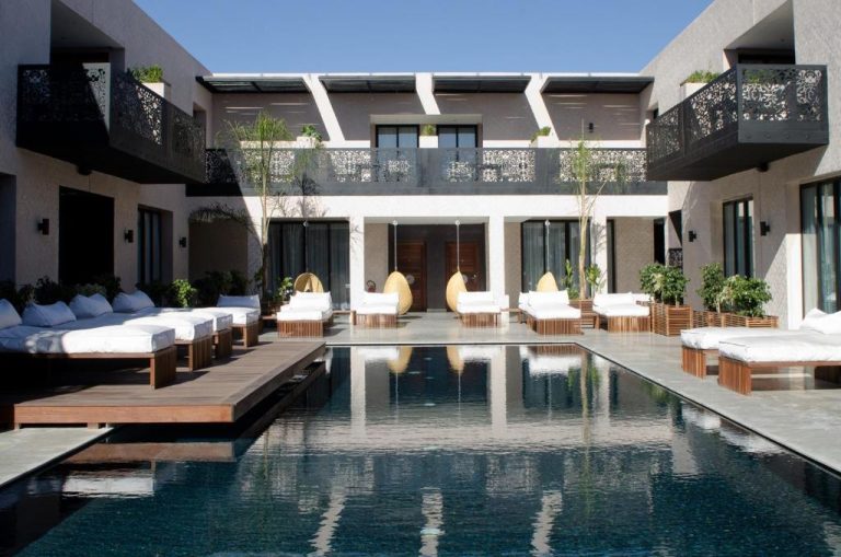 Piscina exterior con tumbonas y balcones del Cesar Resort & Spa rodeada de zonas de relax