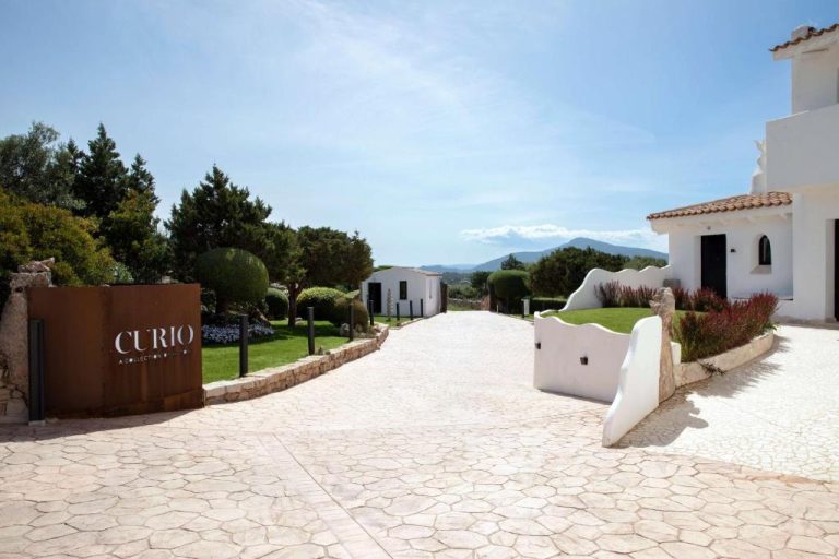 Entrada principal del Sulià House Porto Rotondo Curio Collection by Hilton con jardines y arquitectura blanca mediterránea