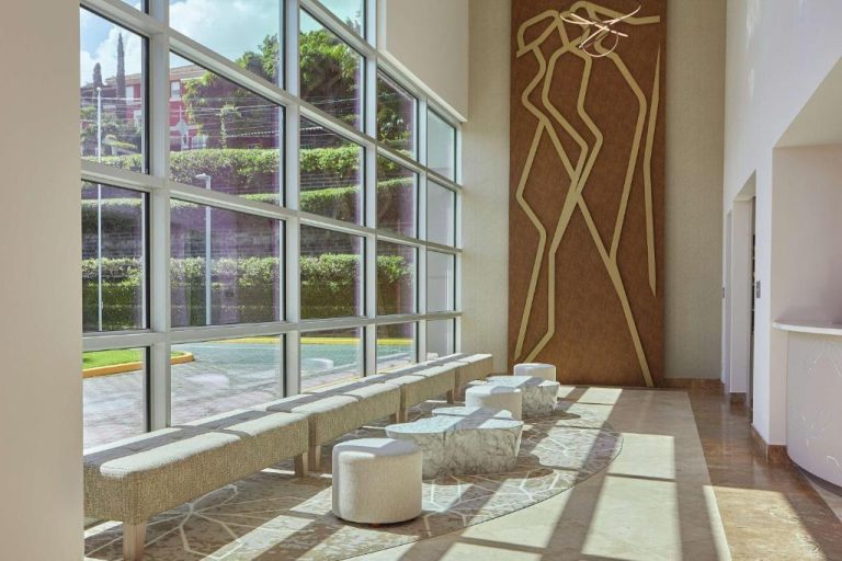 Lobby luminoso con arte decorativo dorado y asientos modernos en DoubleTree by Hilton Managua