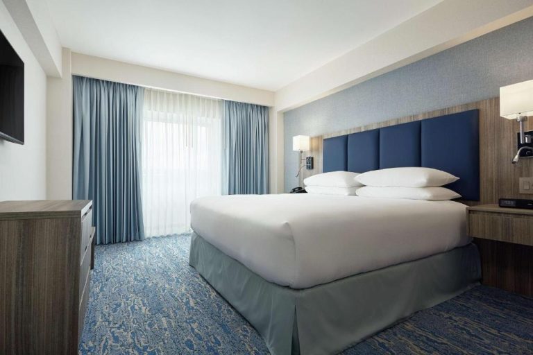 Habitación con cama king size y cabecero azul en el DoubleTree by Hilton Managua