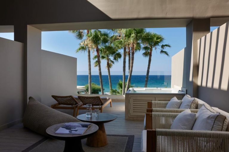 Terraza con sofás y jacuzzi con vistas al mar y palmeras en Atlantica Kalliston Resort Adults Only