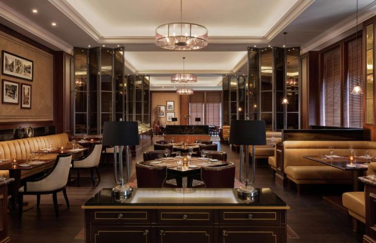 Elegante restaurante interior del Al Habtoor Palace con sofás de cuero y lámparas de araña